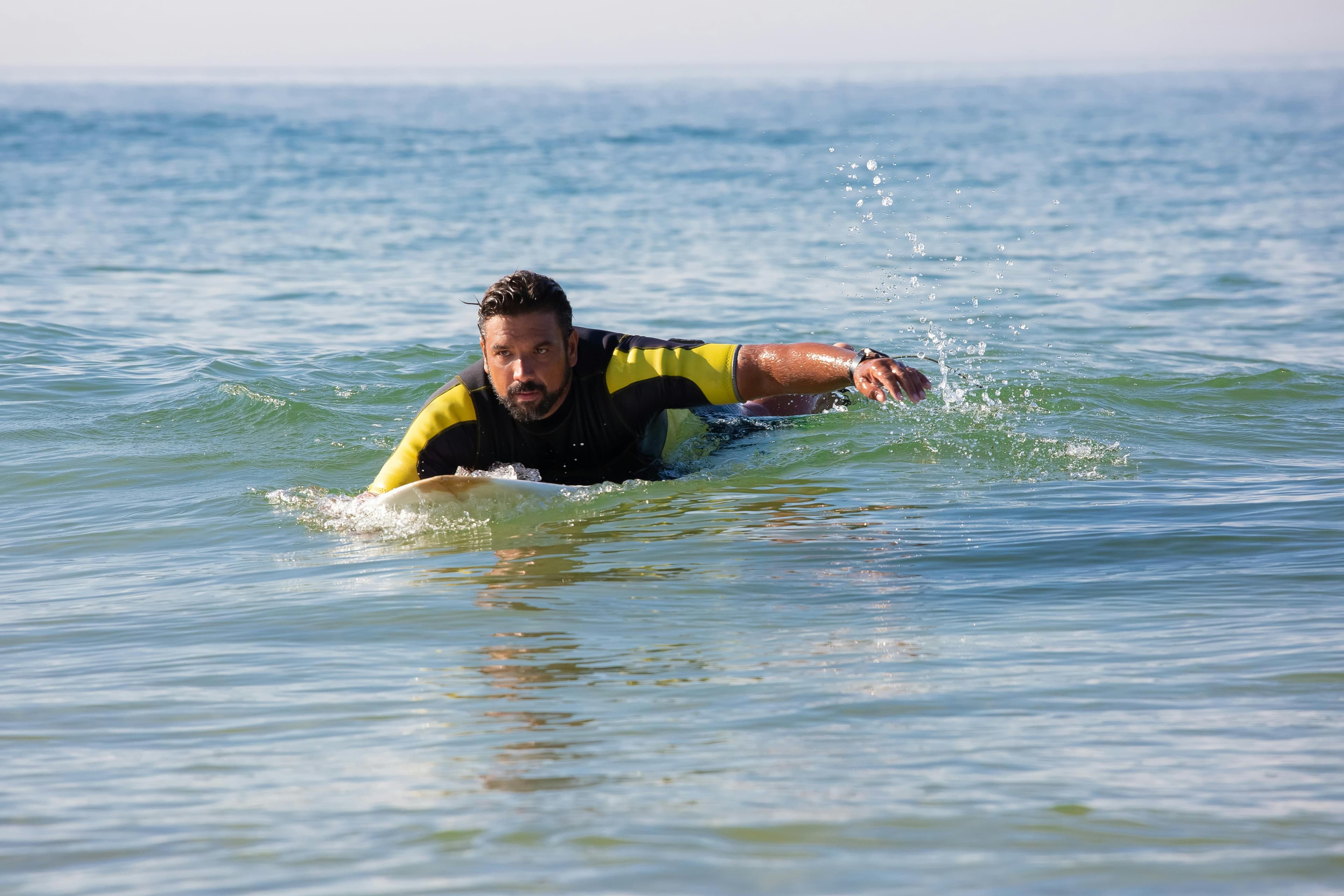 Surfer paddling out during a live lesson at El Tunco